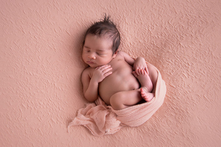 newborn baby girl on pink