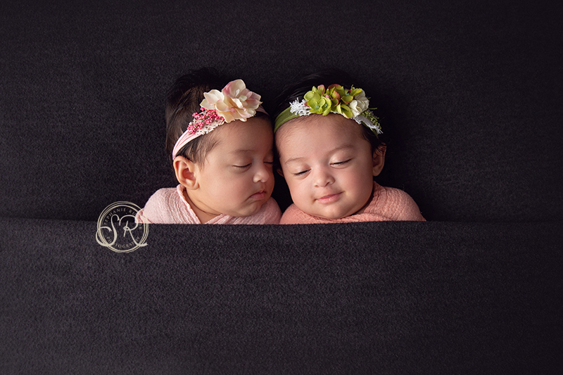 twin newborn girls tucked in