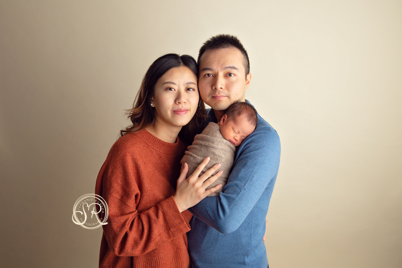New parents holding new baby in Fort Worth studio.