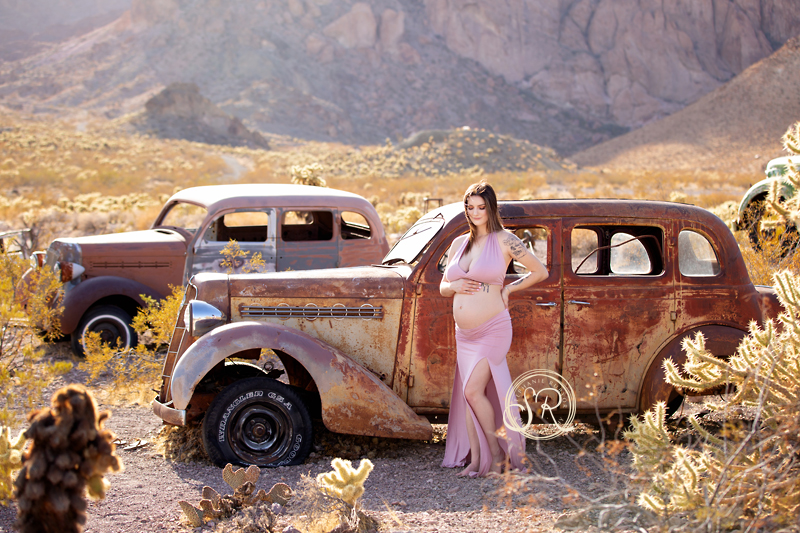 New mama chooses rusty old car in the desert for her maternity session.