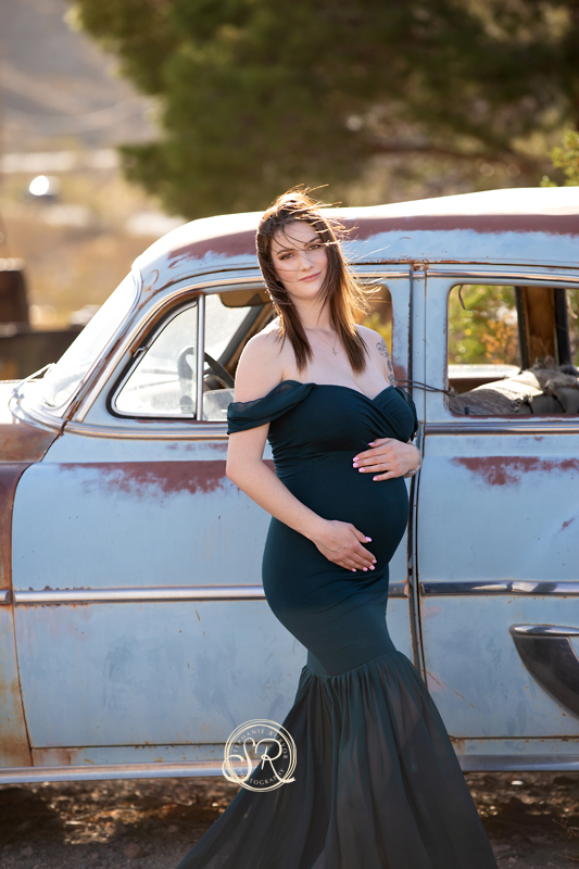 A maternity photo shoot in an old car junkyard makes a great backdrop. 