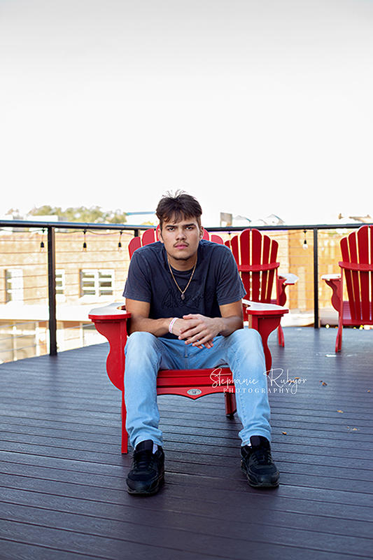 Weston sitting on a rooftop in downtown Fort Worth for his senior photo shoot. 