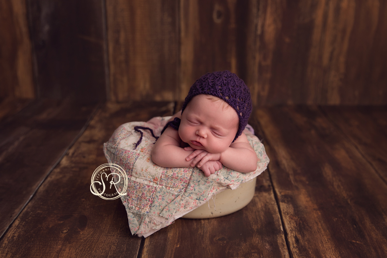 Newborn baby girl sleeping on a quilt at Fort Worth photographer's studio.
