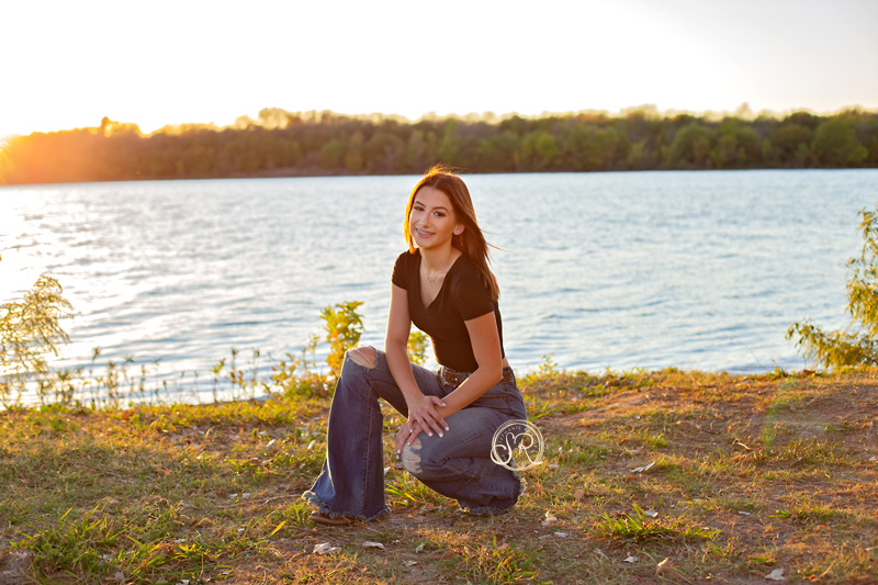 High school senior girl sitting at the park by Marine Creek Lake in Fort Worth, TX.