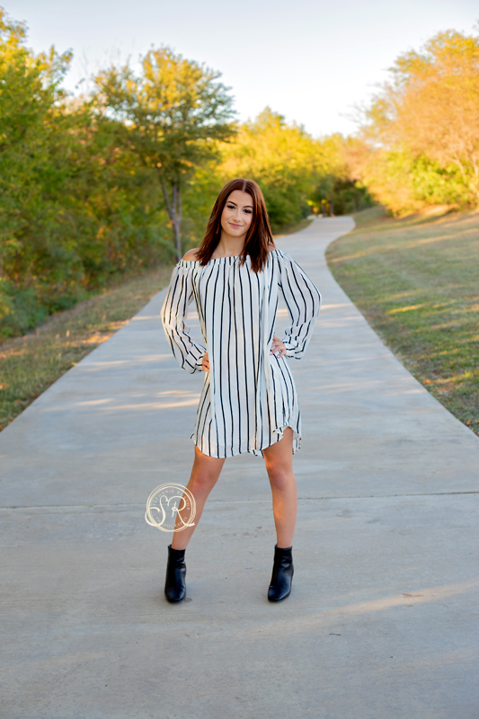 Senior girl in striped dress by her high school in Fort Worth, Texas.