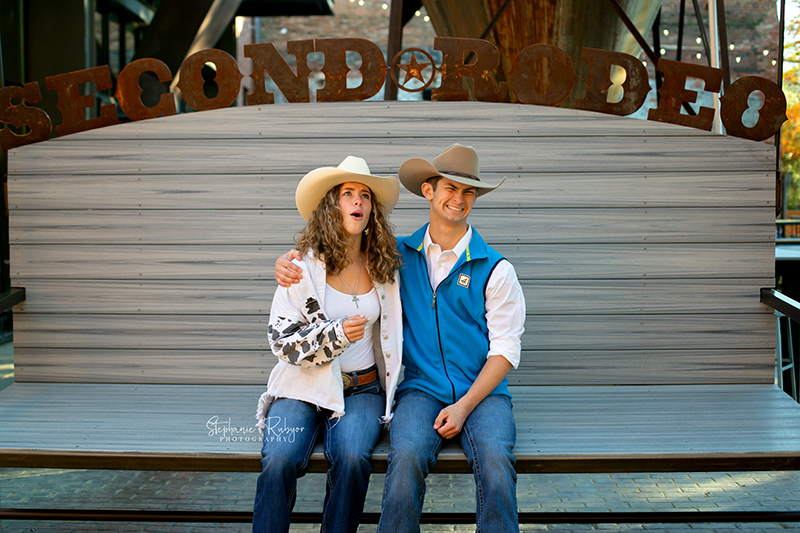 Twin seniors being silly on a bench at their photo session at the Stockyards. 