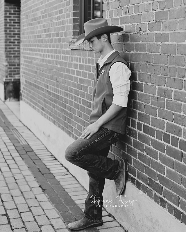 Black and white image of a senior boy at the Stockyards in downtown Fort Worth, Texas. 