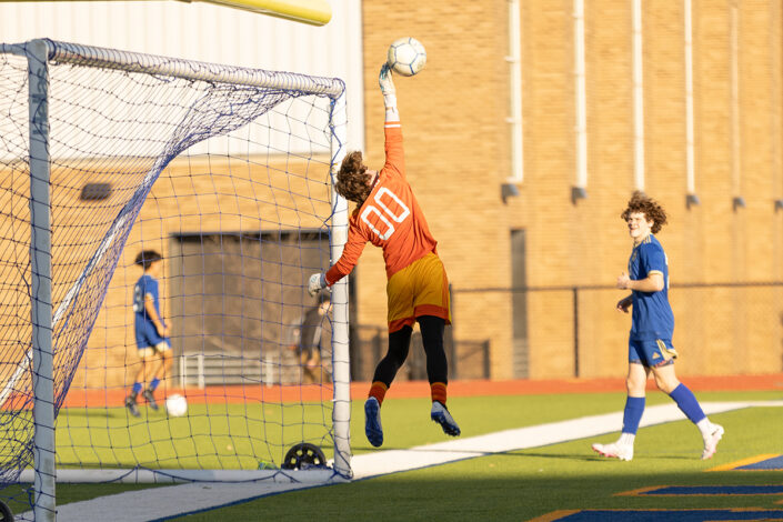 Soccer goalie saving a goal at a soccer game at a Fort Worth high school.