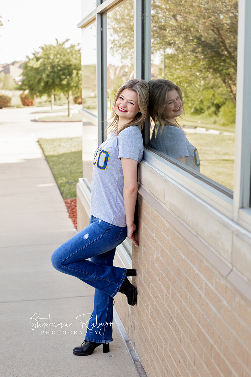 Senior girl leaning against a library wall in Fort Worth Texas. 