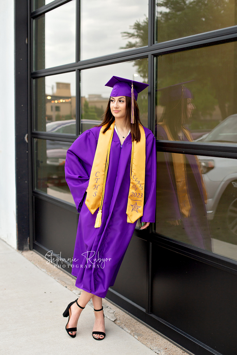 High senior photo session for girl in downtown Fort Worth at the Foundry Art District dressed in graduation cap and gown.