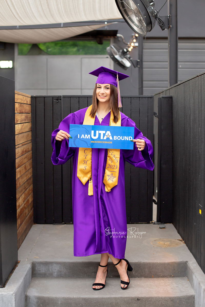 High senior photo session for girl in downtown Fort Worth at the Foundry Art District dressed in graduation cap and gown.