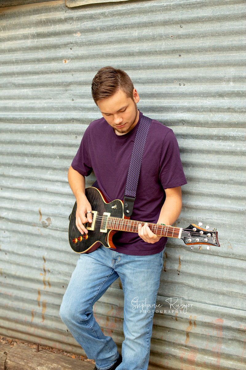 Guy playing his guitar at Eagle Mountain Park in Fort Worth for his senior photo session. 