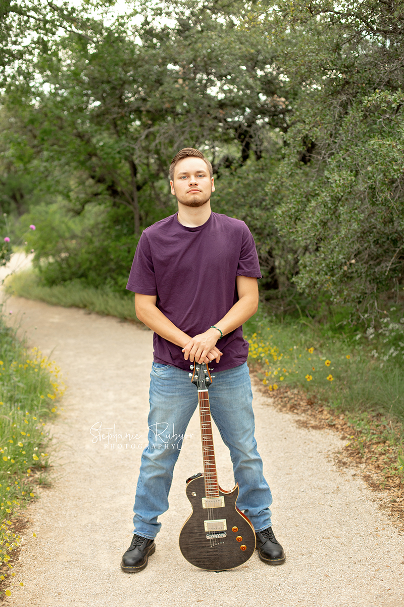 Guy playing his guitar at Eagle Mountain Park in Fort Worth for his senior photo session. 