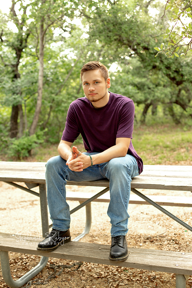 High school senior guy posing on a park bench in Lake Worth, Texas for a photo shoot. 