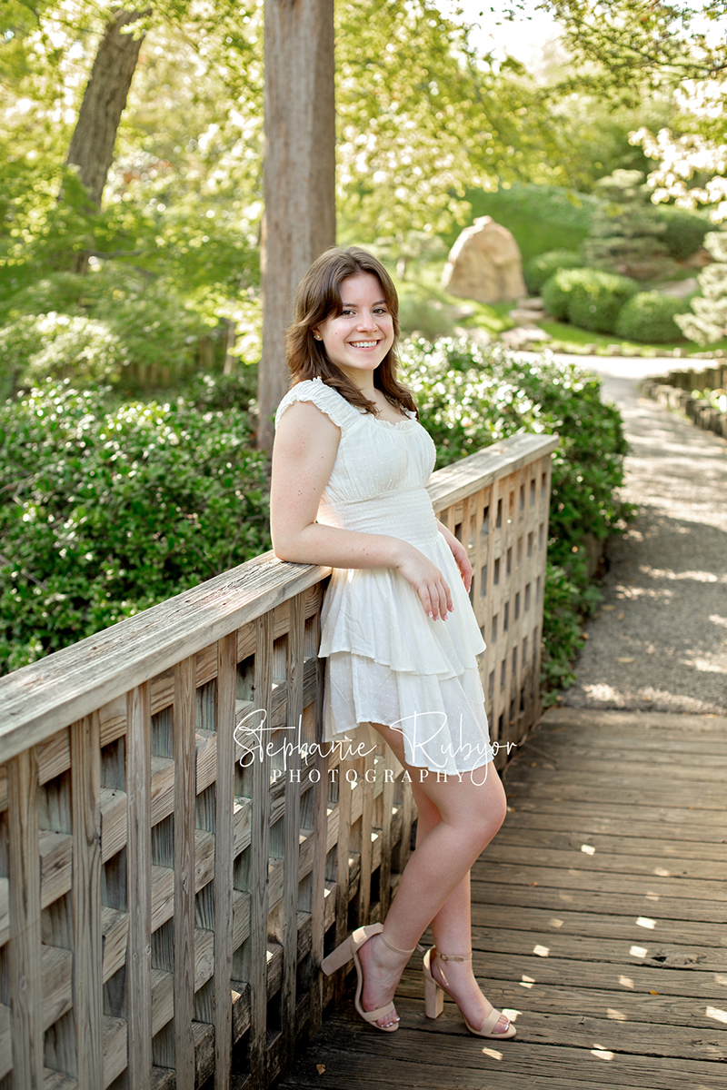 Reilly is posing for her senior session at the Fort Worth Botanic Gardens in the summer before her senior year.