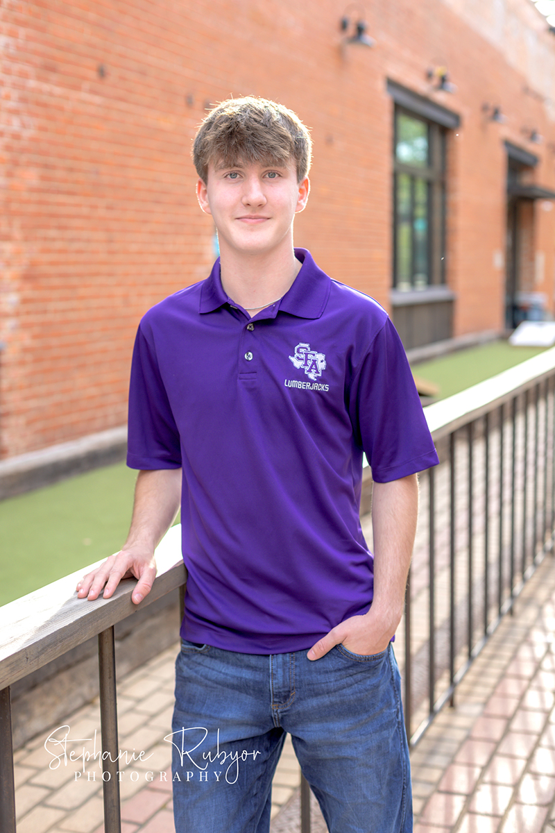 High school senior guy posing for senior portraits at the Stockyards in Fort Worth, Texas. 