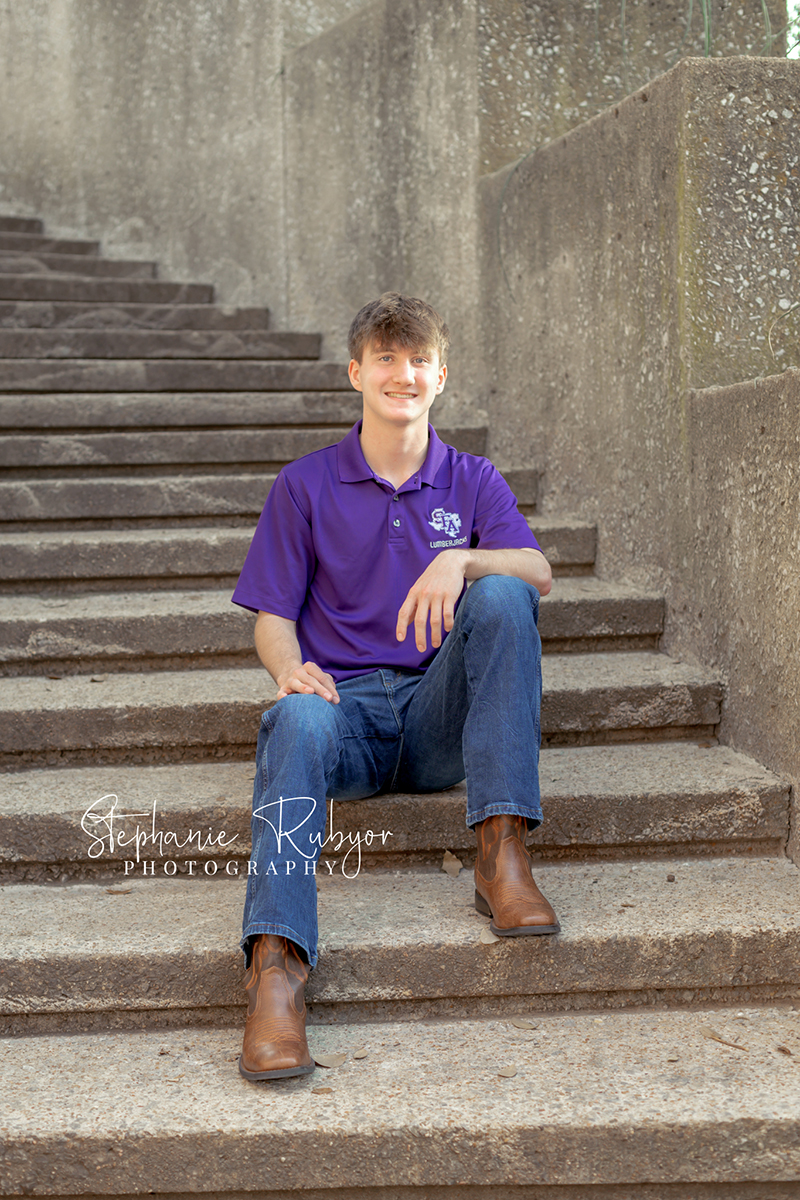 High school senior guy posing for senior portraits at the Stockyards in Fort Worth, Texas. 