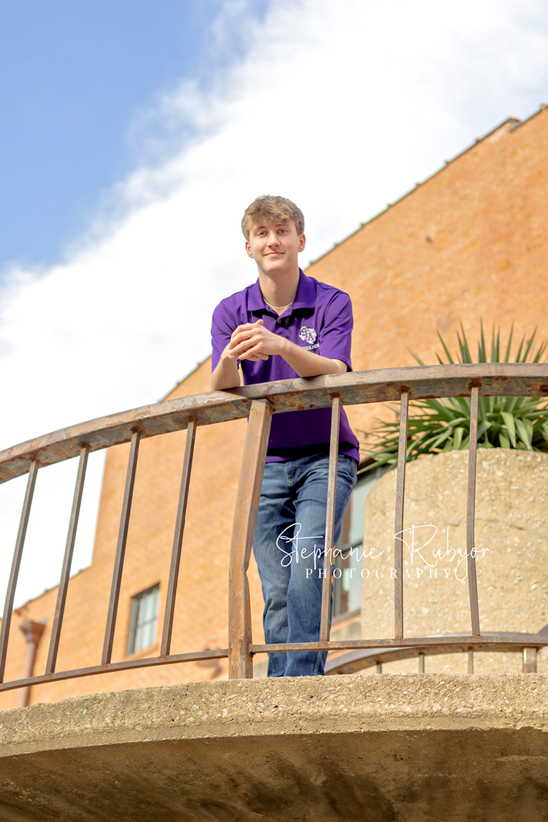 High school senior guy posing for senior portraits at the Stockyards in Fort Worth, Texas. 