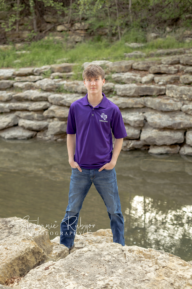 High school senior guy posing for senior portraits at the Stockyards in Fort Worth, Texas. 