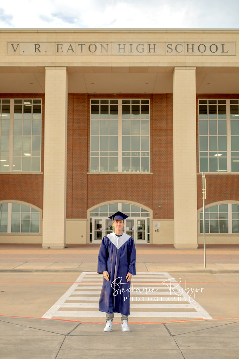 Brayden posing at Eaton High School in his cap & gown in Haslet, Texas for his senior photo session. 