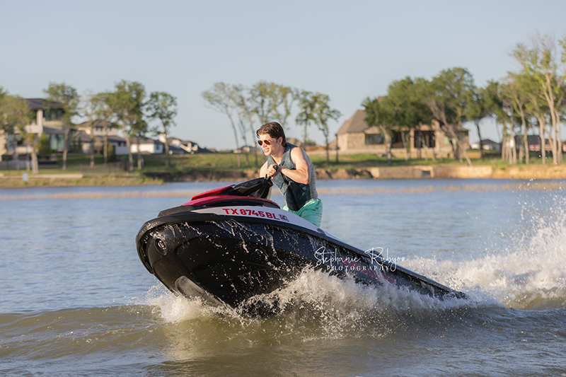 High School senior boy jet skiing on Eagle Mountain Lake for his senior pictures session. 