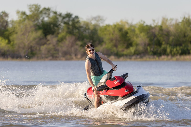 High School senior boy jet skiing on Eagle Mountain Lake for his senior pictures session. 