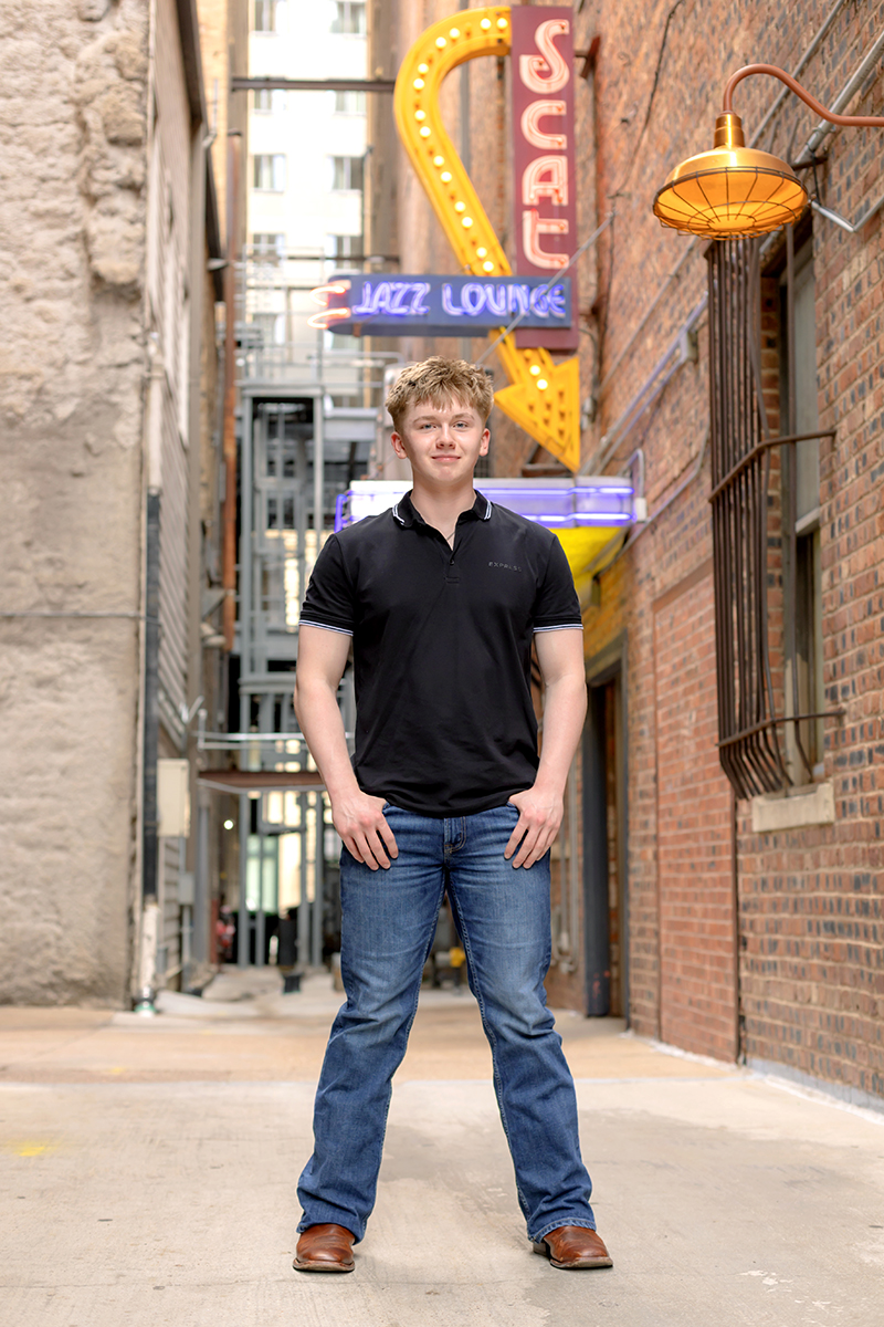Senior guy posing for high school graduation portraits at Sundance Square. 