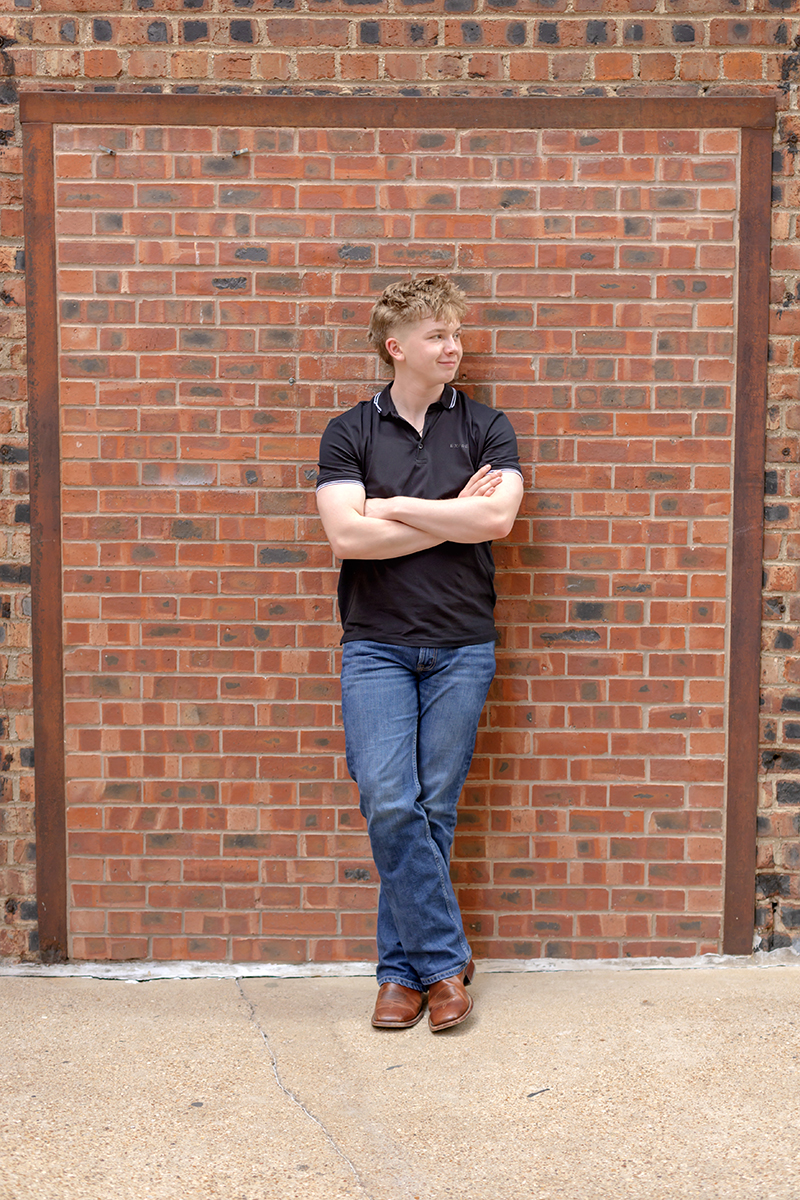 Senior guy posing for high school graduation portraits at Sundance Square. 