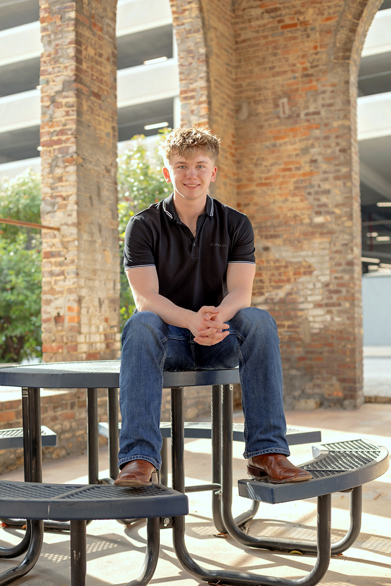 Senior guy posing for high school graduation portraits at Sundance Square. 