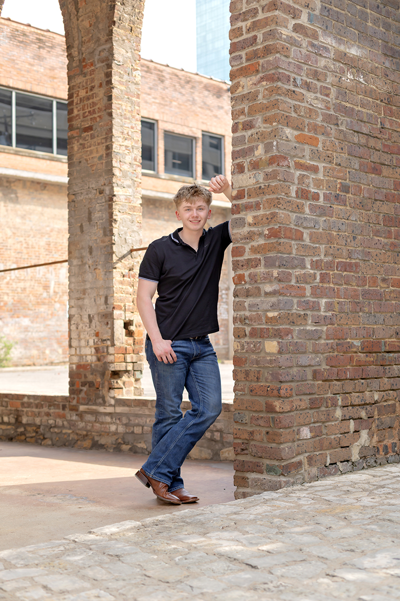 Senior guy posing for high school graduation portraits at Sundance Square. 