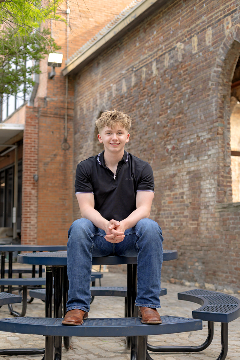 Senior guy posing for high school graduation portraits at Sundance Square. 