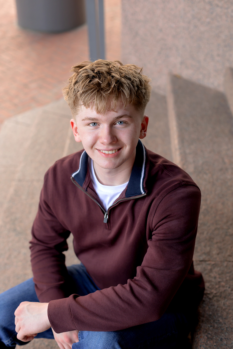 Senior guy posing for high school graduation portraits at Sundance Square. 
