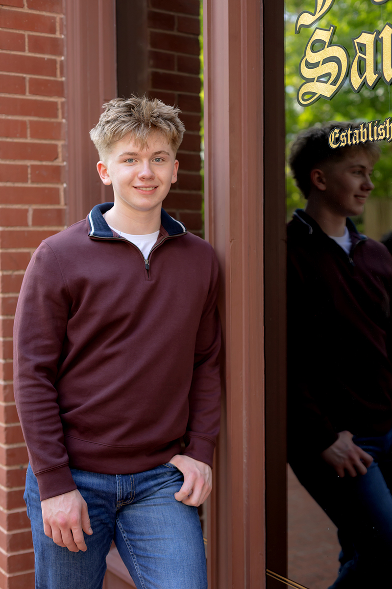 Senior guy posing for high school graduation portraits at Sundance Square. 