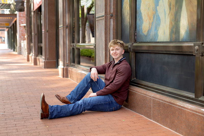 Senior guy posing for high school graduation portraits at Sundance Square. 