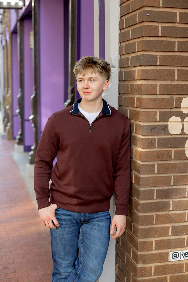 Senior guy posing for high school graduation portraits at Sundance Square. 