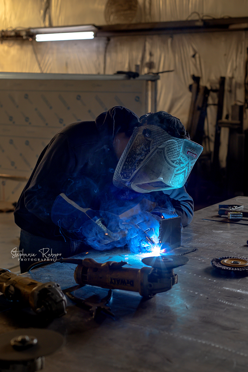 High school senior welding at a local shop for his senior pictures. 