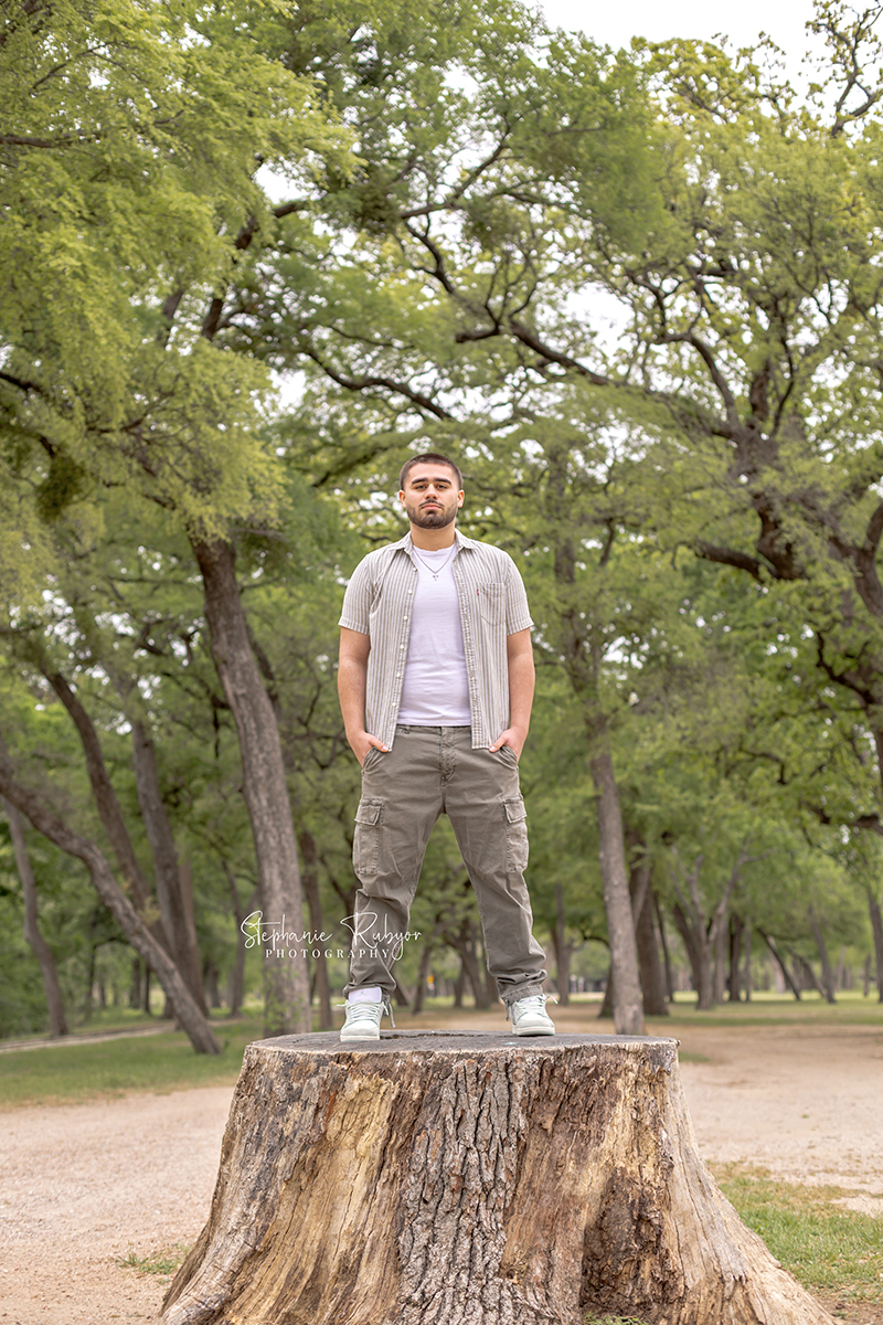 High school senior guy posing for his senior session at Trinity Park in Fort Worth. 