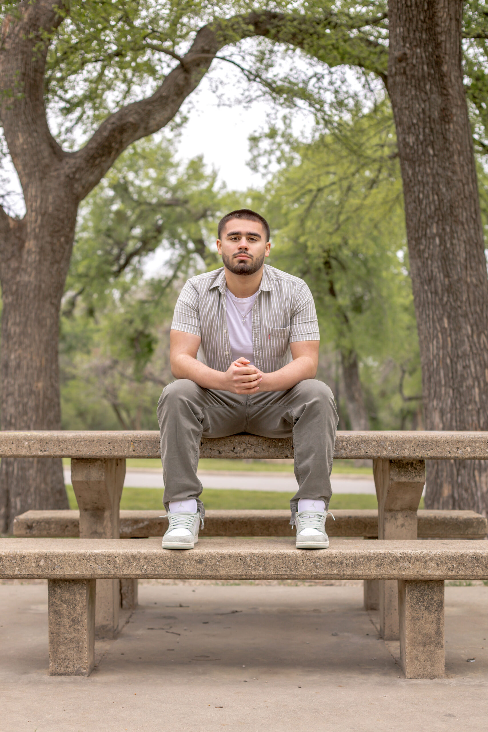 High school senior guy posing for his senior session at Trinity Park in Fort Worth. 