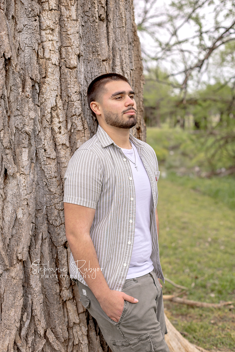 High school senior guy posing for his senior session at Trinity Park in Fort Worth. 