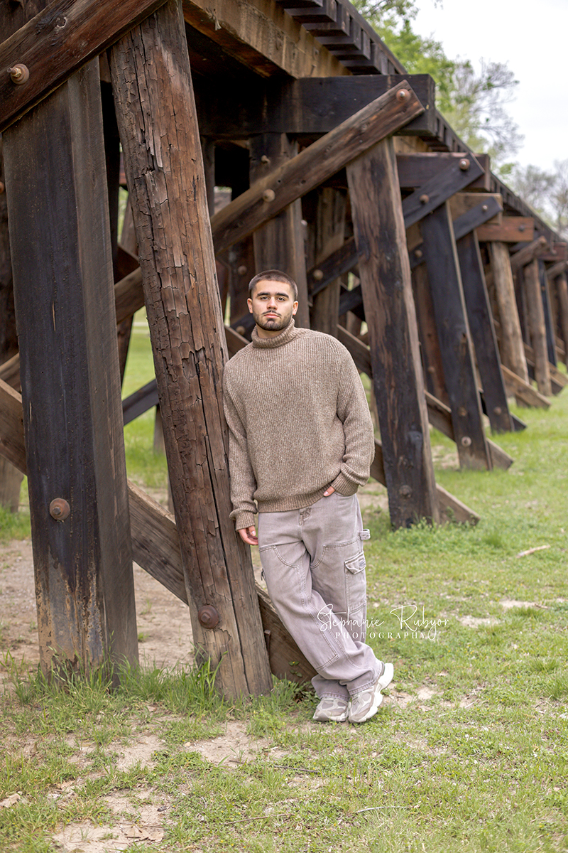 High school senior guy posing for his senior session at Trinity Park in Fort Worth. 