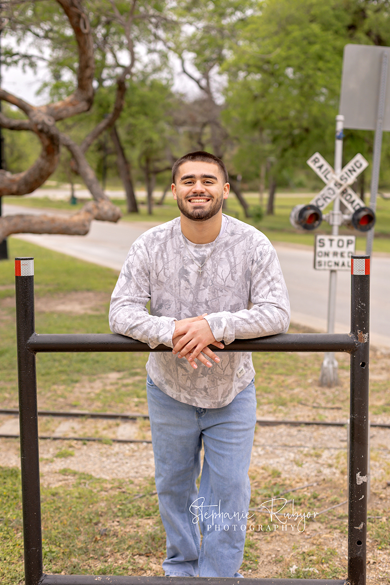 High school senior guy posing for his senior session at Trinity Park in Fort Worth. 