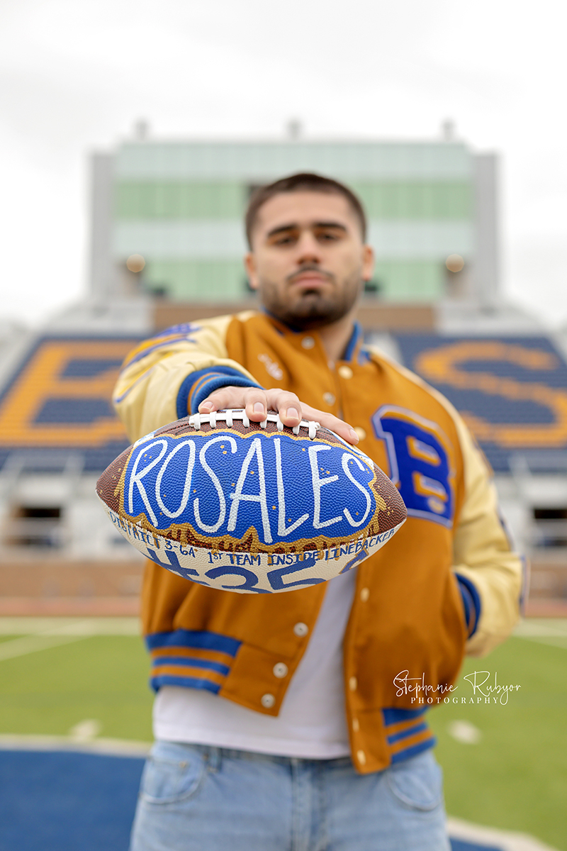 Nate is posing for his senior pictures in his high school football stadium in Saginaw. 