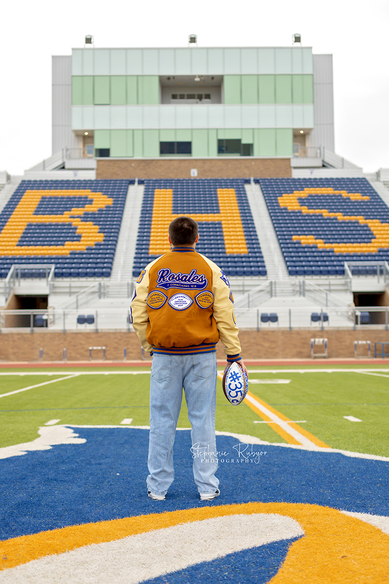 Nate is posing for his senior pictures in his high school football stadium in Saginaw. 