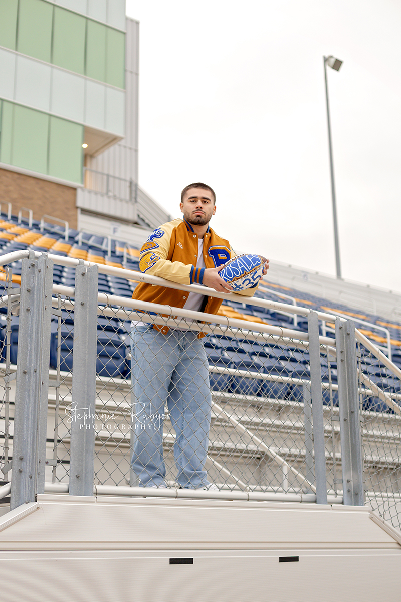 Nate is posing for his senior pictures in his high school football stadium in Saginaw. 