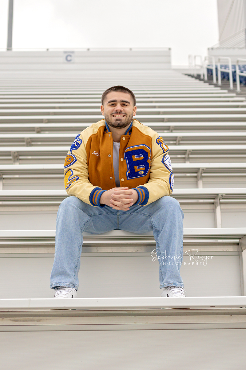 Nate is posing for his senior pictures in his high school football stadium in Saginaw. 