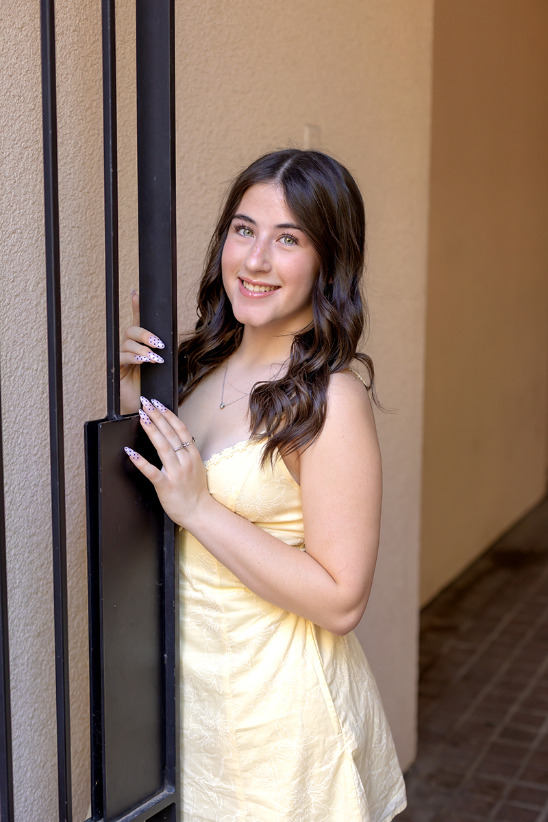 Senior gal posing for pictures in a yellow sundress at Sundance Square downtown Fort Worth. 